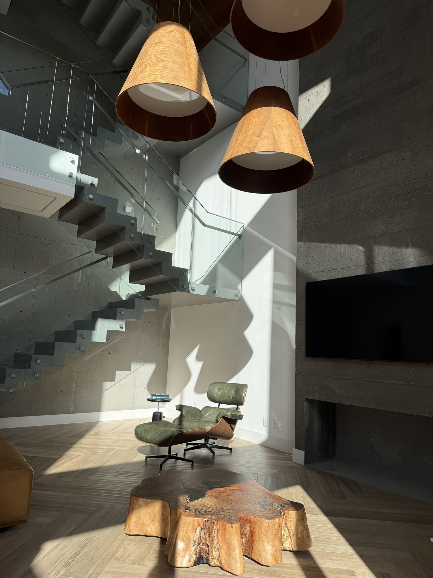 Sunlit concrete stair beneath cone pendant lights